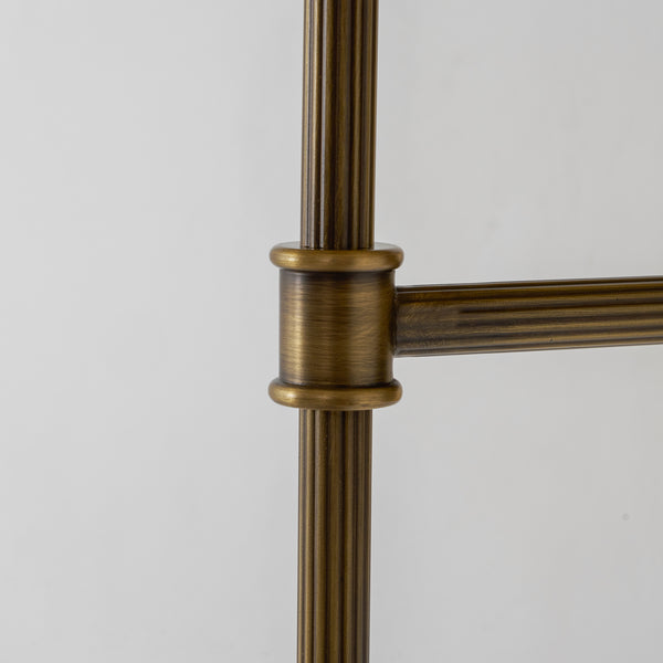 Close-up of the fluted antique brass rod and ribbed collar on the Rhodes wall sconce