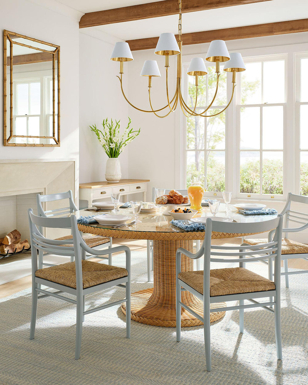 Brass chandelier with fabric shades over a round dining table