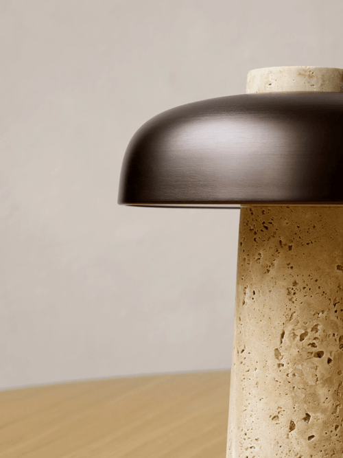 Close-up of the raw travertine cone and bronze shade on the Reverse table lamp
